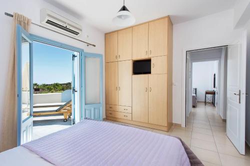 a bedroom with a large bed and a balcony at Ann-Margo House in Fira