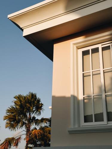 a window on the side of a house with a palm tree at Kula Kara Villas Uluwatu in Uluwatu