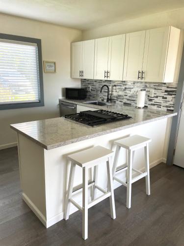 a kitchen with a counter and two stools at a island at Your Slice of Paradise in Kona - Walk to Beach and Stores in Kailua-Kona