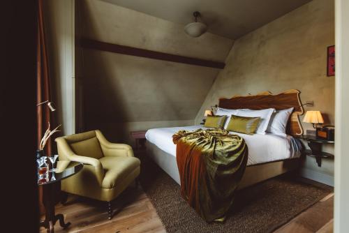 a hotel room with a bed and a chair at De Durgerdam, Amsterdam in Amsterdam