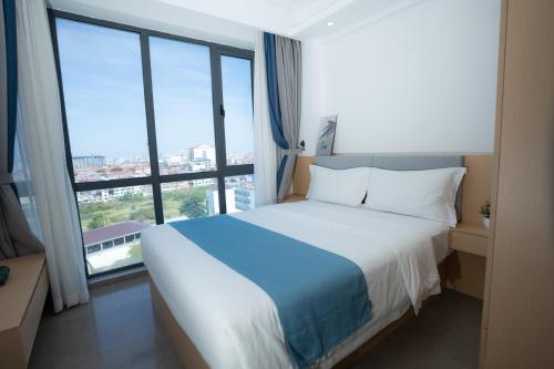 um quarto com uma cama grande e uma janela grande em ARK House em Phnom Penh