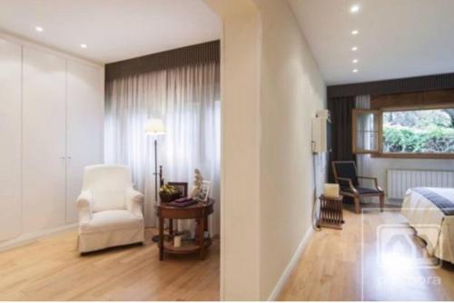 een slaapkamer met een bed en een kamer met een stoel bij Preciosa habitación en suite in Algete