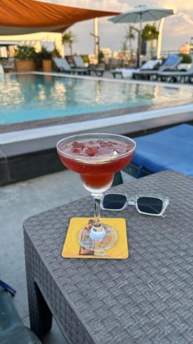 a drink sitting on a table next to a pool at Hotel Sun in North Nicosia