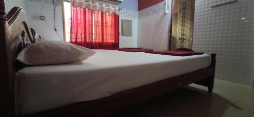 a bed in a room with a red window at shree katyayani residency in Gokarna