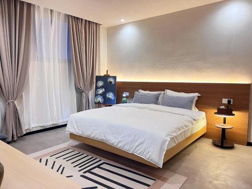 1 dormitorio con cama grande y ventana grande en 松玉枫民宿, en Guiyang