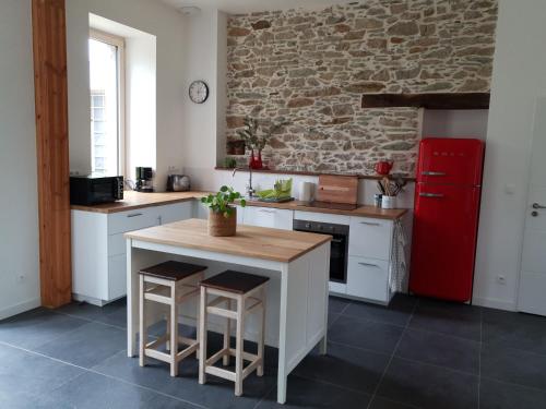 La cuisine est équipée de placards blancs et d'un réfrigérateur rouge. dans l'établissement Superbe maison de campagne à deux pas de Nantes, à Treillières
