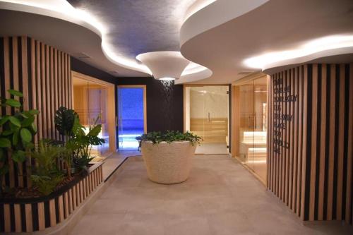 a hallway with a large potted plant in a building at Apartman Lux Relax nalazi se u Titovoj vili in Palisad