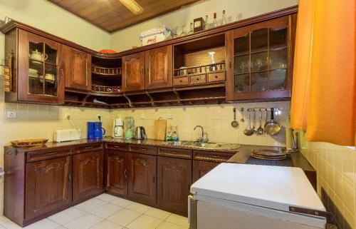 a kitchen with wooden cabinets and a white refrigerator at Bliss Villa Bentota in Aluthgama