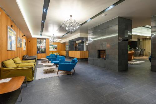 a lobby with blue chairs and a fireplace at HVD Grand Hotel Suhl Business & Leisure in Suhl