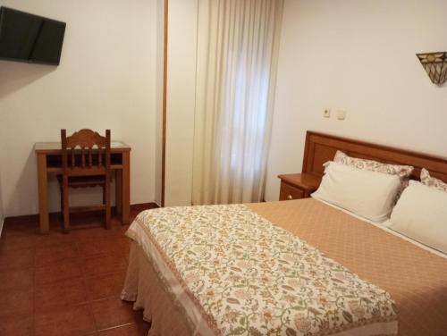 a bedroom with a bed and a table and a chair at Hospedaje Magallanes in Santander