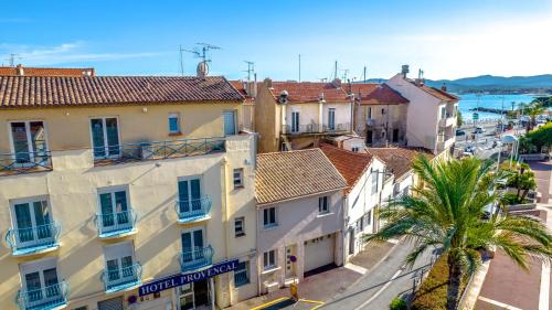 a city street with buildings and a palm tree at Hotel Provencal in Saint-Raphaël