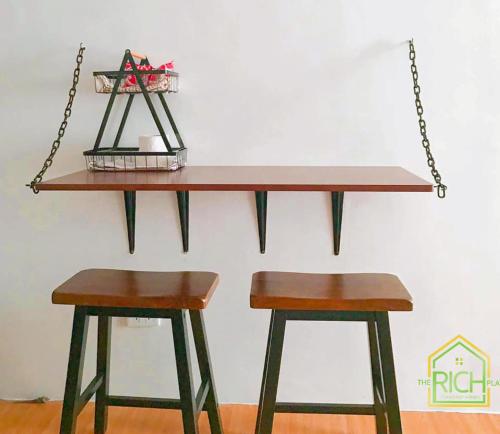 a table and two stools in a room at Black & Bold - 1BR Condo 50mbpsWIFI near SM Marilao in Marilao