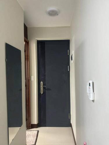 a hallway with a black door in a room at Ross' Cosy Corner in Lapu Lapu City