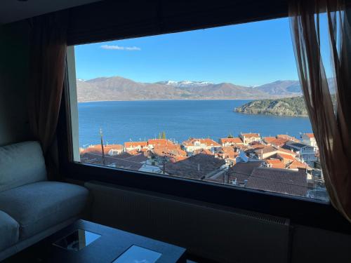 a window with a view of a city and water at sunlight loft in Kastoria