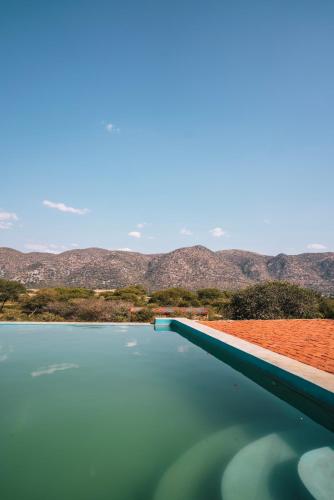 a pool of water with mountains in the background at Otavi Vineyards Self-Catering & Camping in Otavi