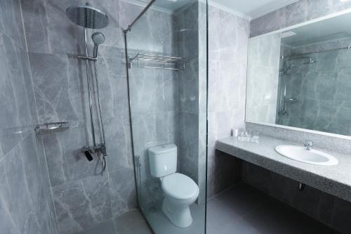 a bathroom with a shower and a toilet and a sink at Sindoro Hotel Cilacap By Conary in Cilacap