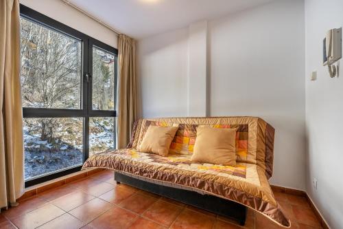 um sofá num quarto com uma grande janela em Monte Gorbea 7 J em Sierra Nevada