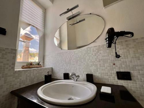 La salle de bains est pourvue d'un lavabo et d'un miroir. dans l'établissement Casa Oh! Rapallo, à Rapallo