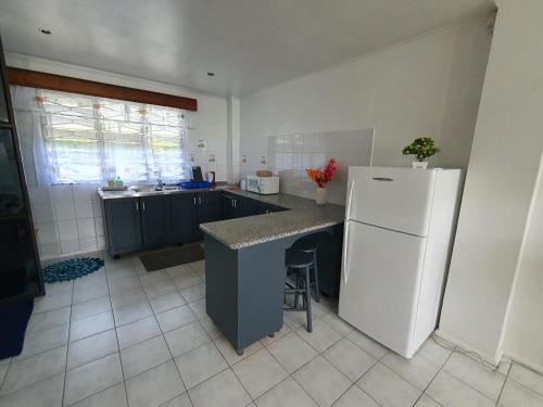 a kitchen with a white refrigerator and a counter at Cosy 2 bedroom unit with pool,Wifi in Suva