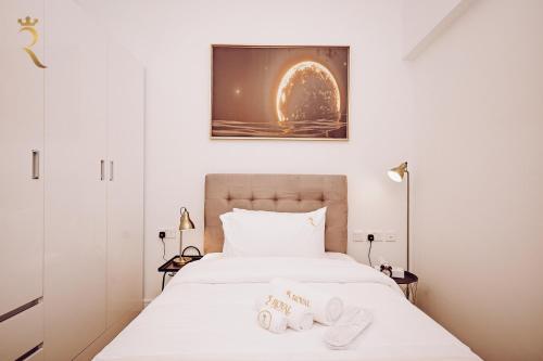 a bedroom with a bed with two slippers on it at 3BR Al Raha Haven - Chic Coastal Escape in Abu Dhabi