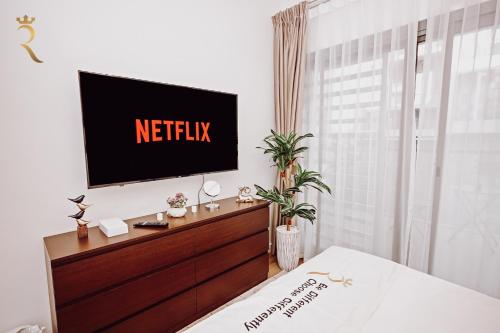 a television on a wall in a bedroom at 3BR Al Raha Haven - Chic Coastal Escape in Abu Dhabi