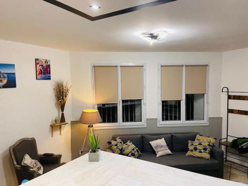 a living room with a couch and some windows at Appartement Collioure centre & GARAGE PRIVATIF in Collioure