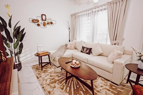 a living room with a white couch and a table at 3BR Al Raha Haven - Chic Coastal Escape in Abu Dhabi