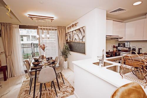 a kitchen and dining room with a table and chairs at 3BR Al Raha Haven - Chic Coastal Escape in Abu Dhabi