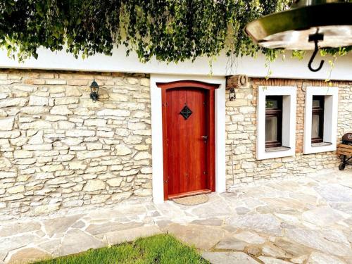 a red door on a stone building with a window at Útulný dům pro odpočinek in Malotice