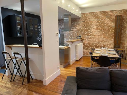 une cuisine et un salon avec une table et des chaises dans l'établissement L'Étage, hypercentre Toulousain, Climatisé, à Toulouse