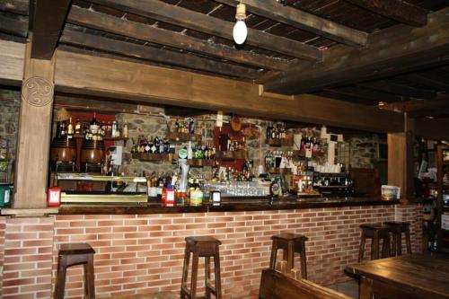 a bar with a brick wall and some bar stools at Hotel Rural El Reundu in Campomanes
