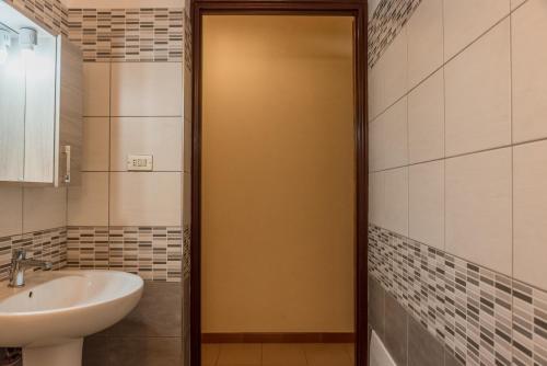 a bathroom with a sink and a toilet and a door at Appartamento C - Le Terrazze in Ribera