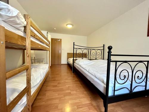 two bunk beds in a room with wooden floors at Apartmán C01 Poustevník in Pec pod Sněžkou
