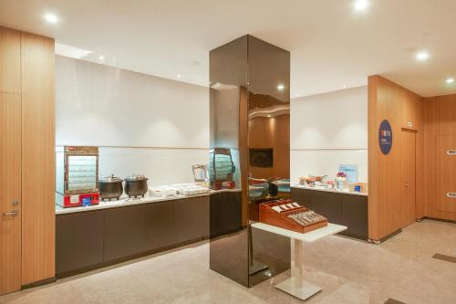 a kitchen with a counter with a cake on a table at Holiday Inn Express Shanghai Xuhui Binjiang, an IHG Hotel in Shanghai