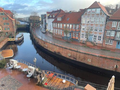 un río con edificios y un barco en una ciudad en Am Fischmarkt en Stade