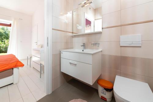 Baño blanco con lavabo y aseo en Vila Monika, en Nova Vas
