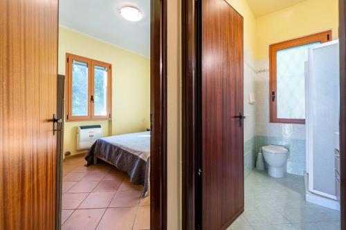 a bedroom with a bed and a bathroom with a toilet at Appartamento Arlecchino in Gargnano