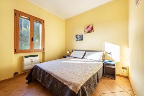a bedroom with a bed and a window at Appartamento Arlecchino in Gargnano