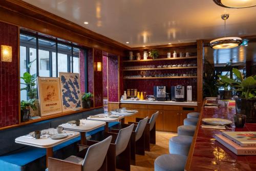 a restaurant with tables and chairs and a bar at Hôtel La Conversation in Paris
