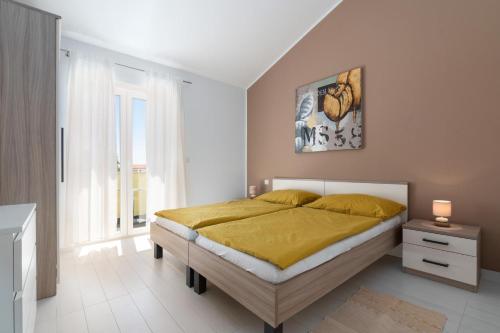 1 dormitorio con 1 cama grande con manta amarilla en Vila Monika, en Nova Vas