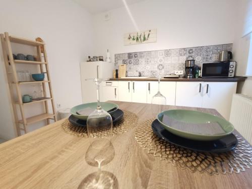 a kitchen with a table with two green plates on it at Boxenstopp in der Vulkaneifel in Boos