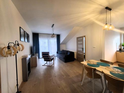 ein Wohnzimmer mit einem Tisch und einem Esszimmer in der Unterkunft Apartament Spokojna Wisła in Wisła