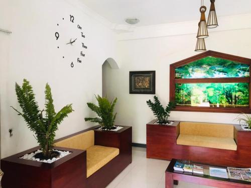 uma sala de espera com um sofá e um relógio na parede em Kandy City Village em Kandy