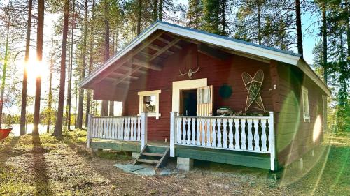 a small red and green house in the woods at Pine Tree Cabin in Lappland in Glommersträsk