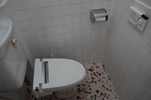 La salle de bains blanche est pourvue de toilettes et d'un lavabo. dans l'établissement 駅から徒歩4分/ビル3階全体/広い部屋/広い屋上/和室/レインボーブリッジ/お台場, à Tokyo