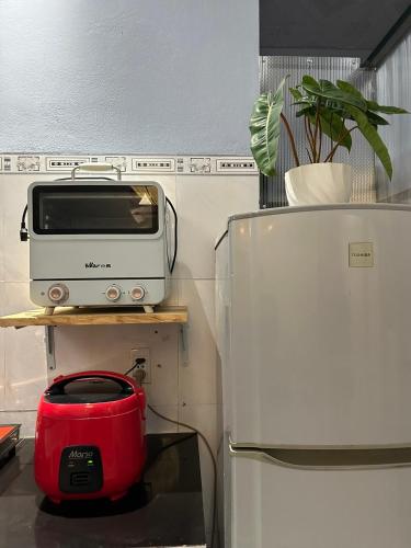a toaster sitting on a shelf next to a refrigerator at Chang's Hideaway homestay ConDao in Con Dao