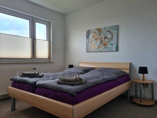 een slaapkamer met een groot bed en een paarse deken bij Gästewohnung KL. WZL 30_5 