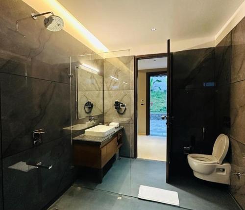 a bathroom with a toilet and a sink and a shower at Sajjan Bagh Resort Kumbhalgarh in Kumbhalgarh