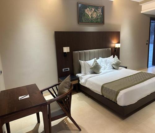 a bedroom with a bed and a table and a desk at Sajjan Bagh Resort Kumbhalgarh in Kumbhalgarh