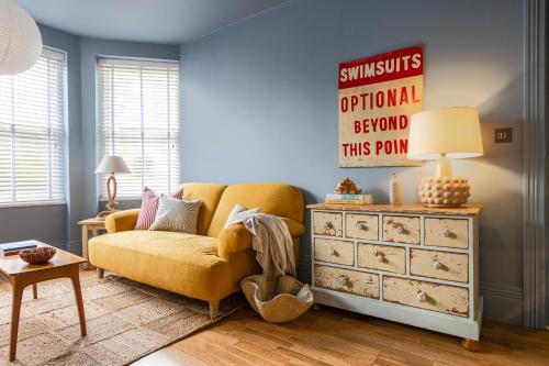 uma sala de estar com um sofá amarelo e uma cómoda em Brighton Bolthole em Brighton & Hove
